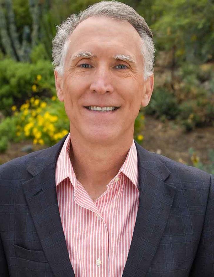 a portrait of strom thacker with the pitzer landscape behind him